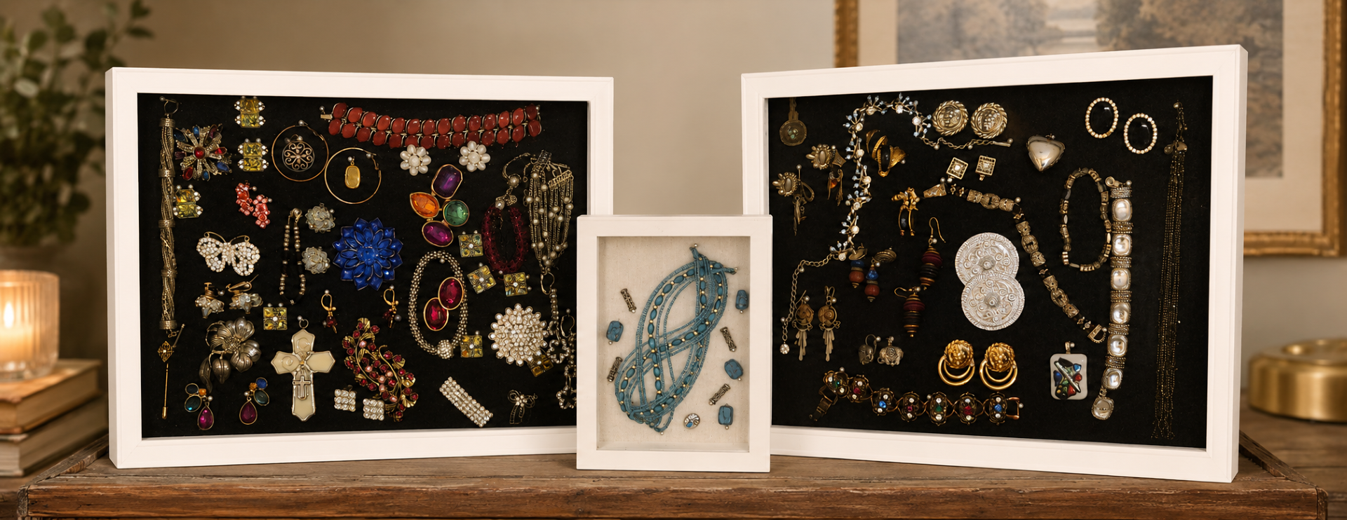 Three shadow box frames displaying a stunning collection of vintage costume jewelry, brooches, earrings, and necklaces